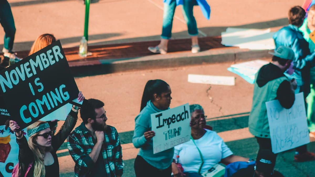 Group of people at a street protest holding political signs in Wheeling, WV.