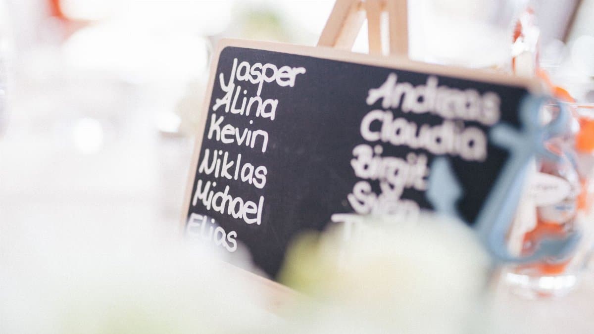 A decorative chalkboard displaying names at a refined indoor gathering.