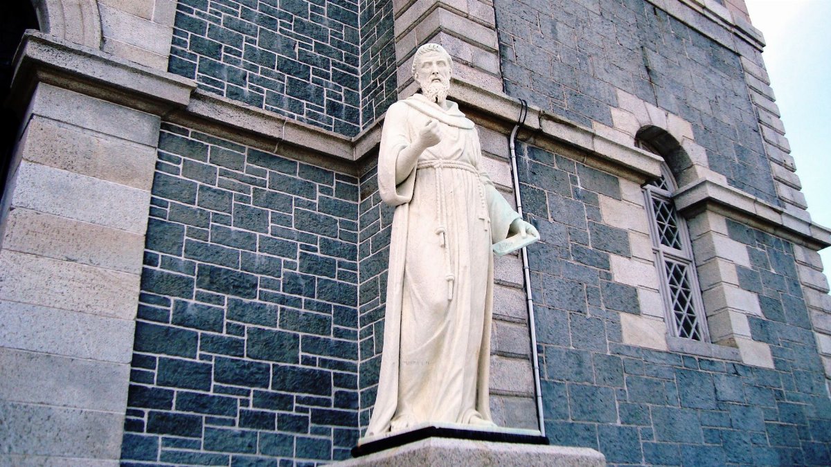 Statue of St. Francis of Assisi against stone wall in St. John's, Newfoundland.