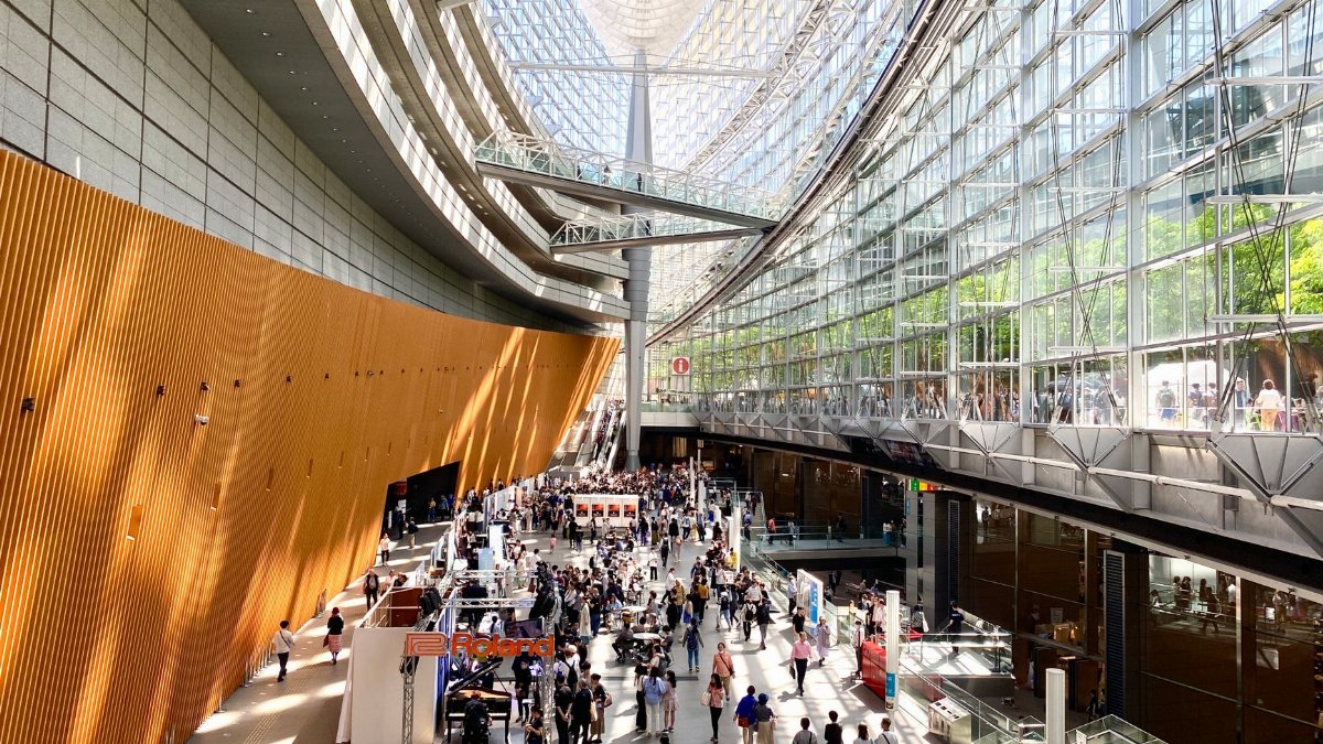 A bustling scene inside the modern architecture of Tokyo International Forum in Japan.