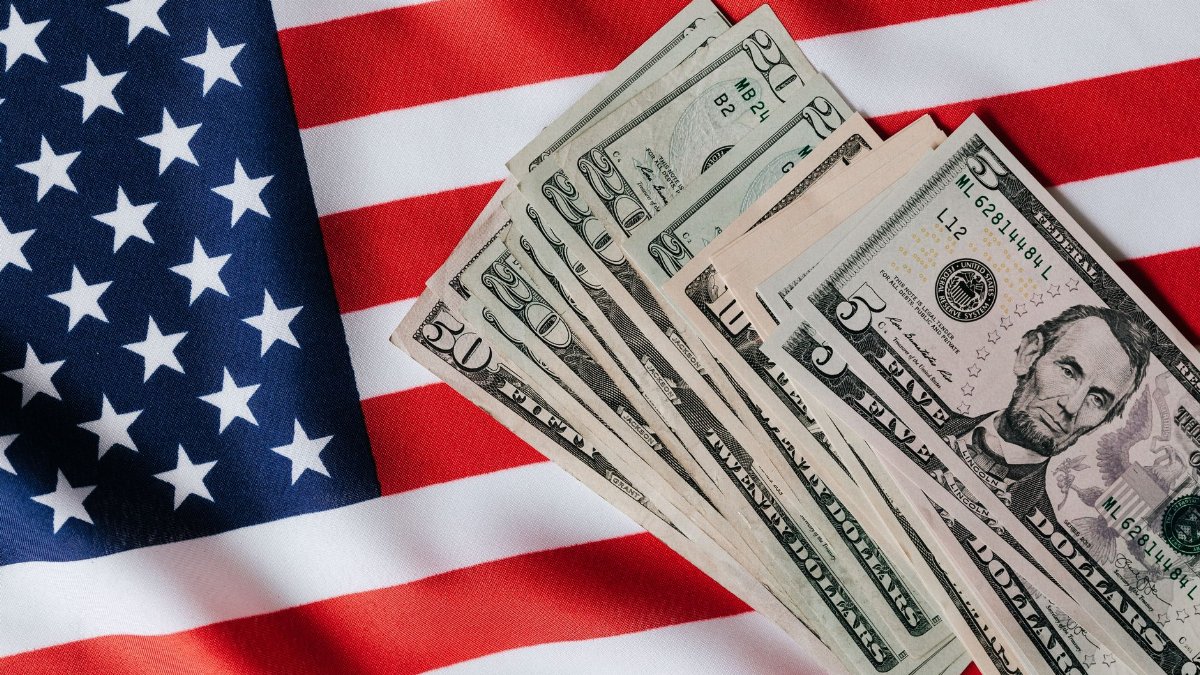 Top view of various dollar banknotes placed on flag of United States of America