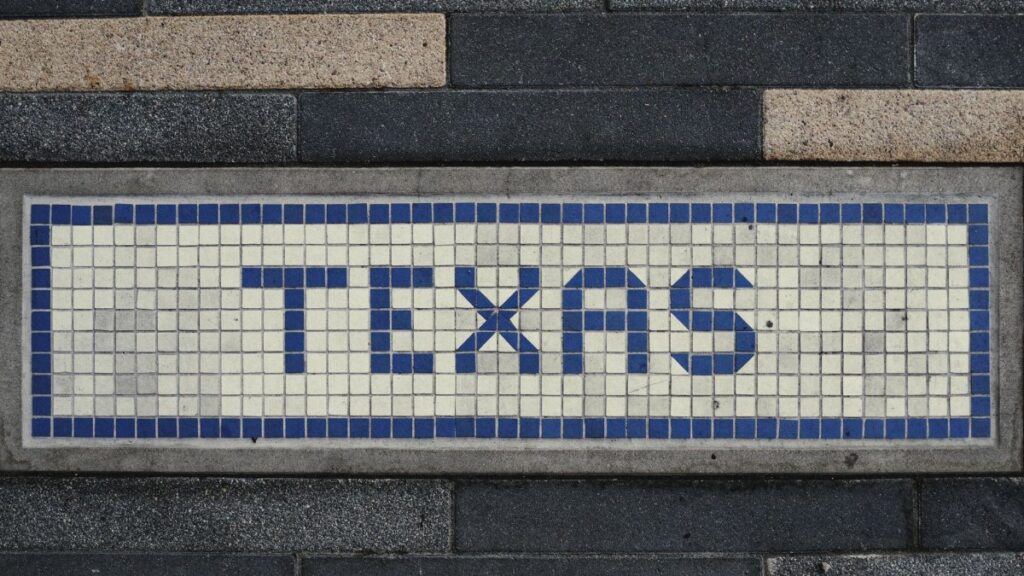 Unique mosaic tile artwork spelling 'Texas' on a sidewalk in Houston, TX.