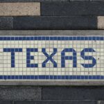 Unique mosaic tile artwork spelling 'Texas' on a sidewalk in Houston, TX.