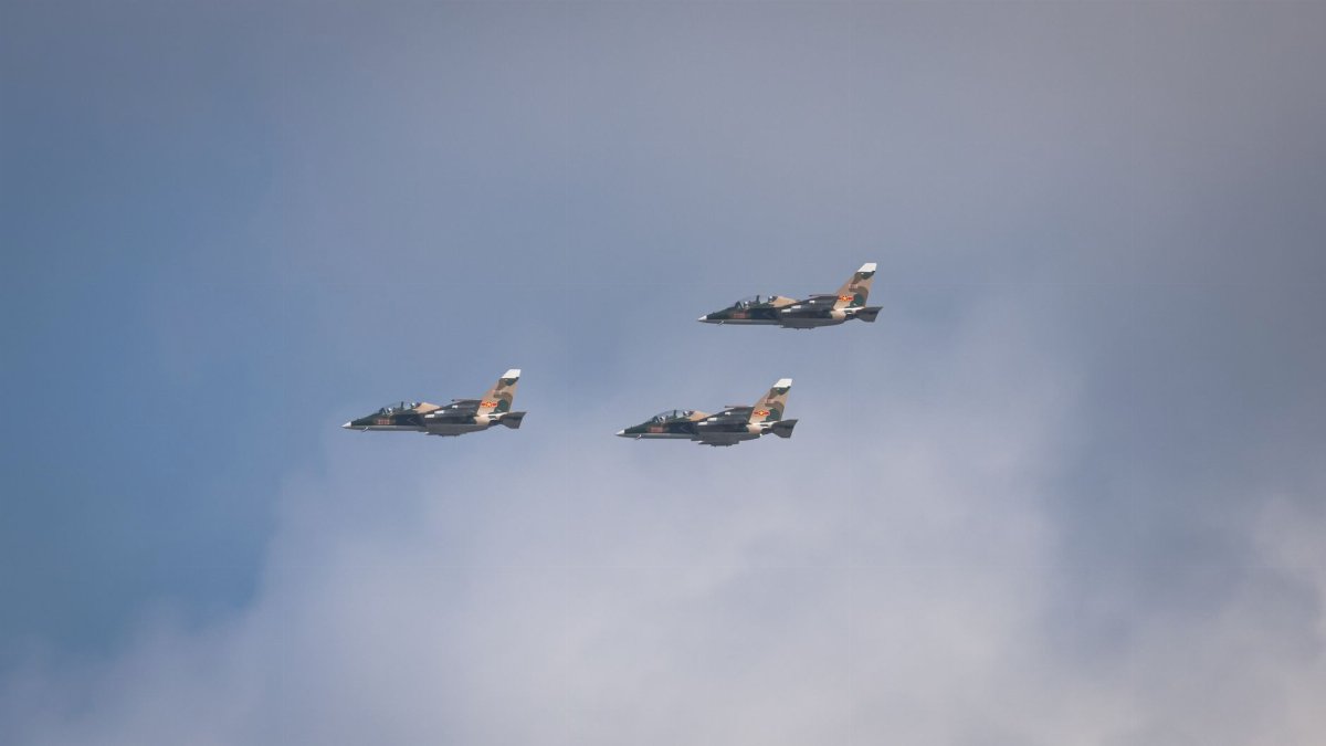 Three fighter jets flying in formation against a clear blue sky.