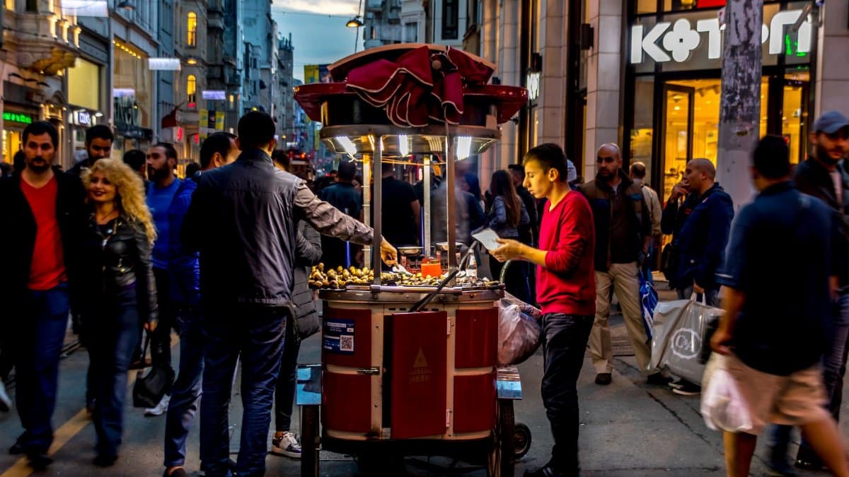 A vibrant street food vendor serving customers in a busy urban setting, capturing the night ambiance.