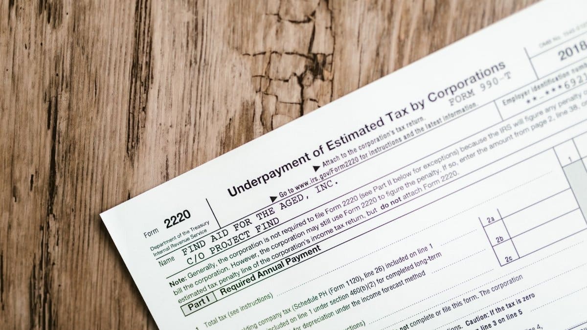 Close-up of a corporate tax form on a textured wooden surface, highlighting document details.