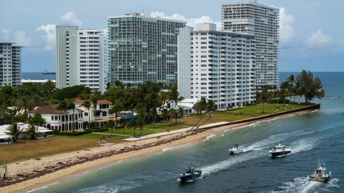 Aerial view of Fort Lauderdale high-rise buildings along the beach with boats on the water, exemplifying coastal city life.