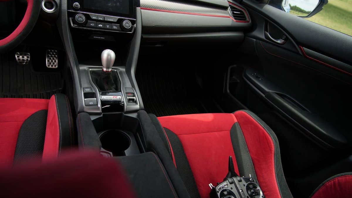 Explore the sleek interior of a Honda Civic Type R with vibrant red accents, showcasing luxury and style.
