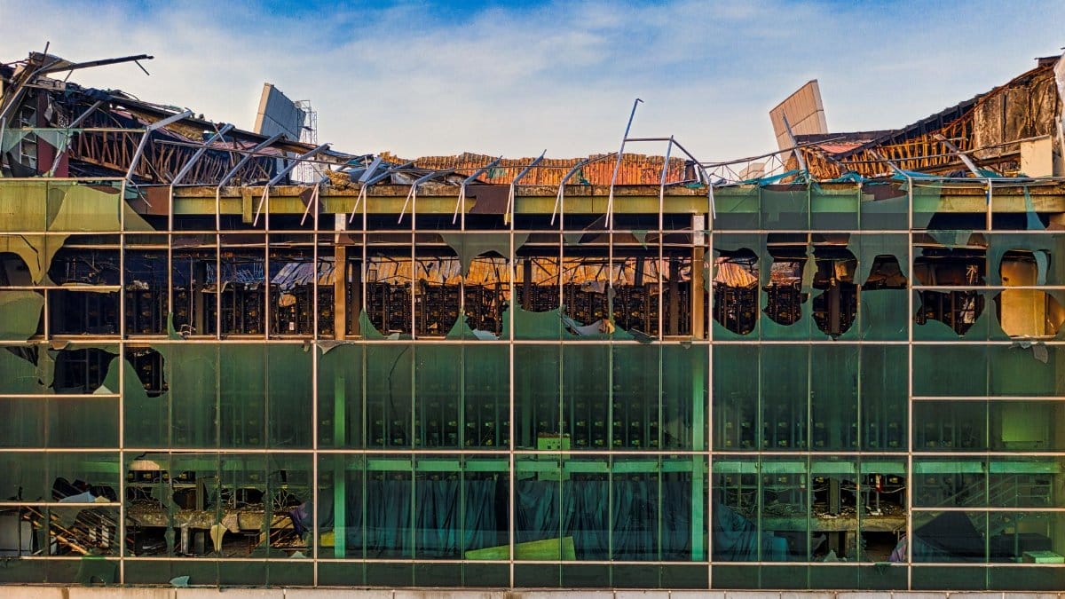 Aerial shot of an abandoned building with shattered glass facade and visible destruction in Indonesia.