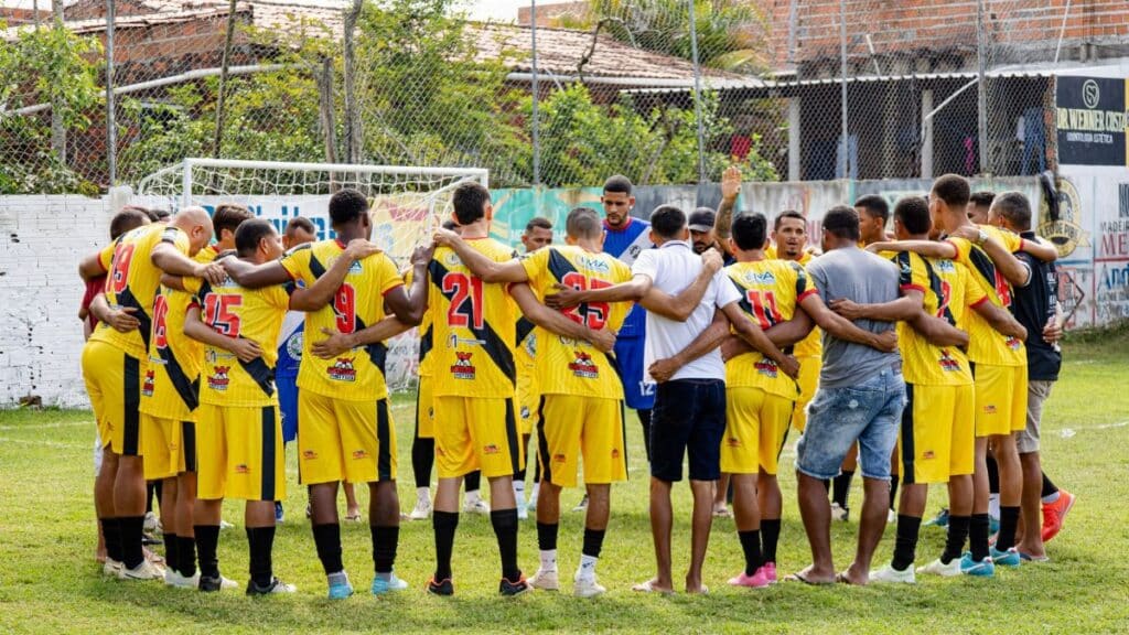 Amateur soccer players huddle on the field, preparing for their match with motivational energy and teamwork.