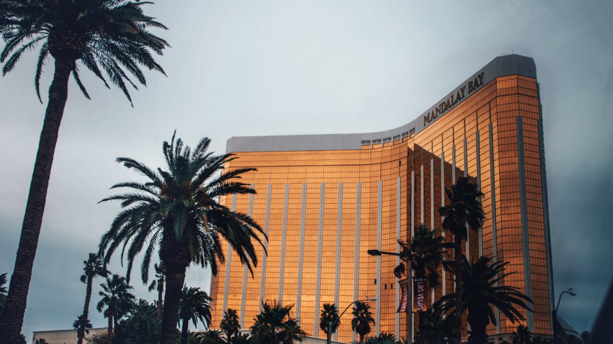 Golden facade of Mandalay Bay Resort amidst palm trees in Las Vegas, Nevada.
