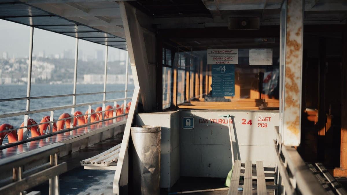 Capture the serene atmosphere during a ferry ride on the Bosphorus with warm lighting.