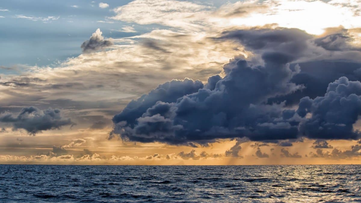 Stunning photo of a dramatic seascape with a vibrant sunset and impressive cloud formations.