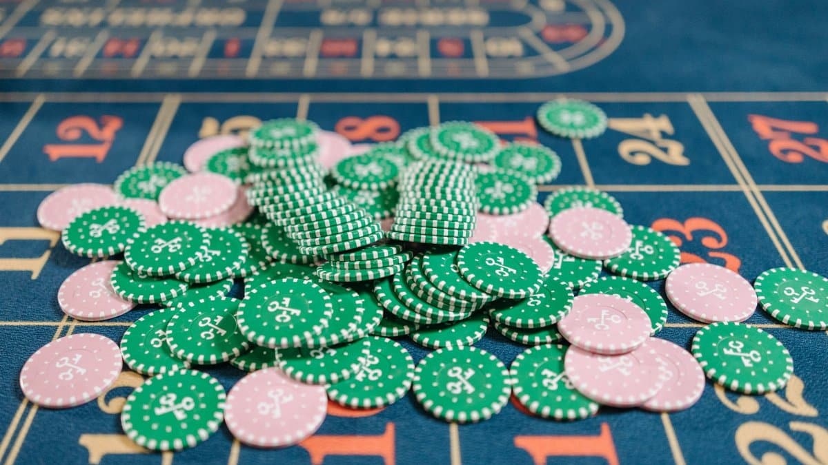 Close-up of a roulette table with a pile of green and pink poker chips.