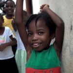A group of happy children enjoying outdoor play on a street in Haiti.
