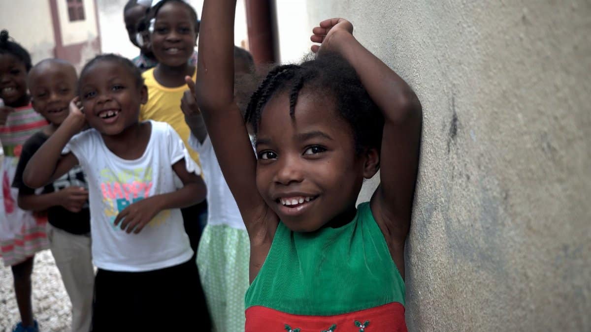 A group of happy children enjoying outdoor play on a street in Haiti.