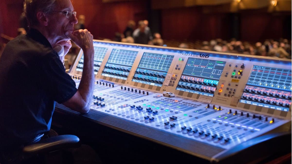 A sound engineer manages the audio control panel at a live music concert, ensuring quality sound.