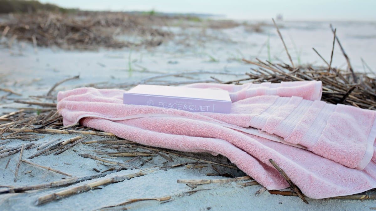 Pink towel and book 'Peace & Quiet' on secluded beach, Hilton Head Island.