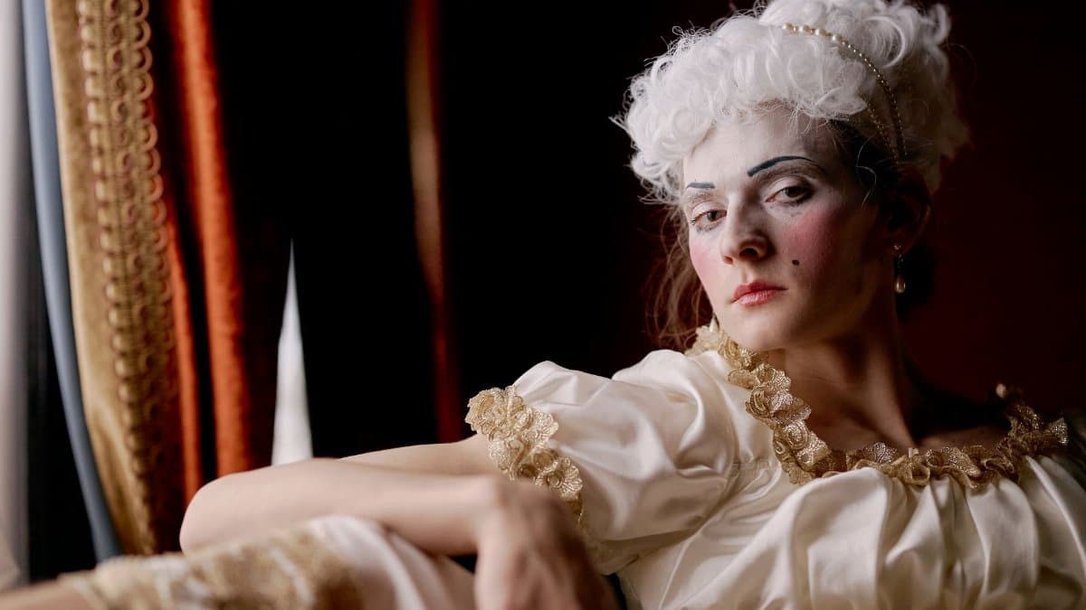 A captivating portrait of a woman in 18th-century costume with intricate makeup.