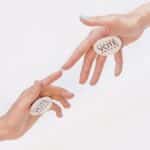 Two hands reaching with vote stickers, symbolizing participation and democracy in elections.