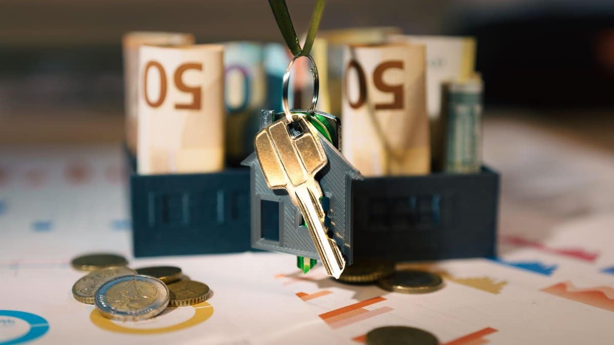 Keys hanging with money and charts, symbolizing real estate investment and financial planning.