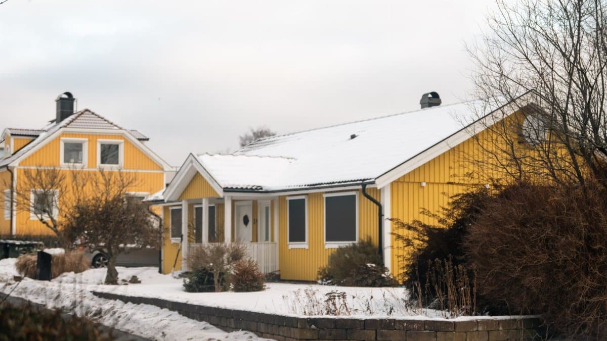 Charming yellow houses in a snowy winter landscape, offering a warm and inviting atmosphere.