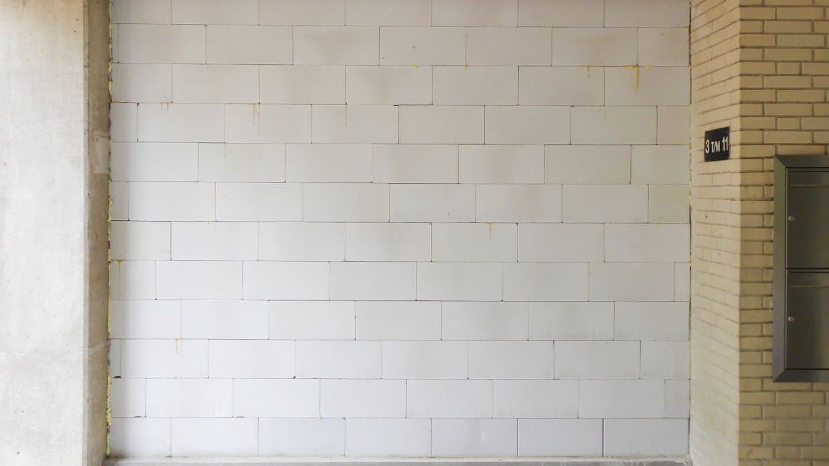 Simple white brick wall interior with concrete accents. Ideal for backgrounds or architectural themes.