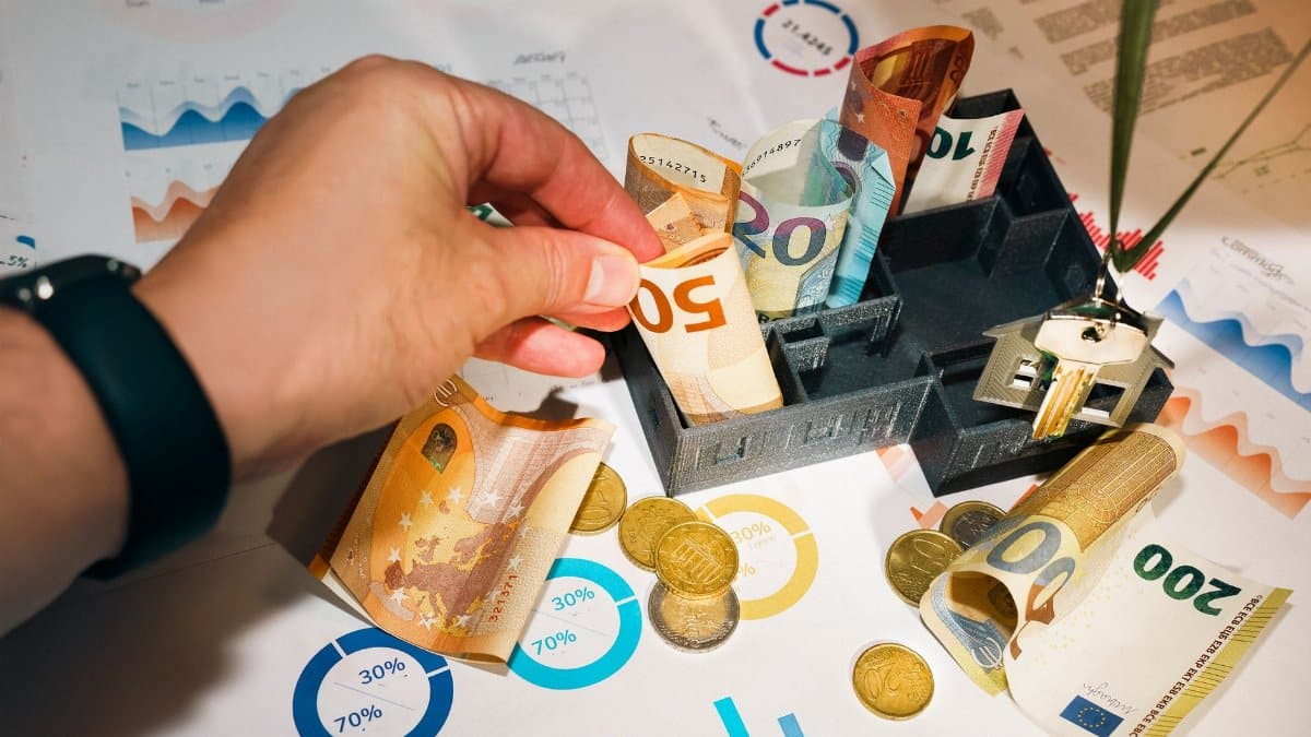 Euro bills and coins with financial charts showcasing budgeting and investment planning.