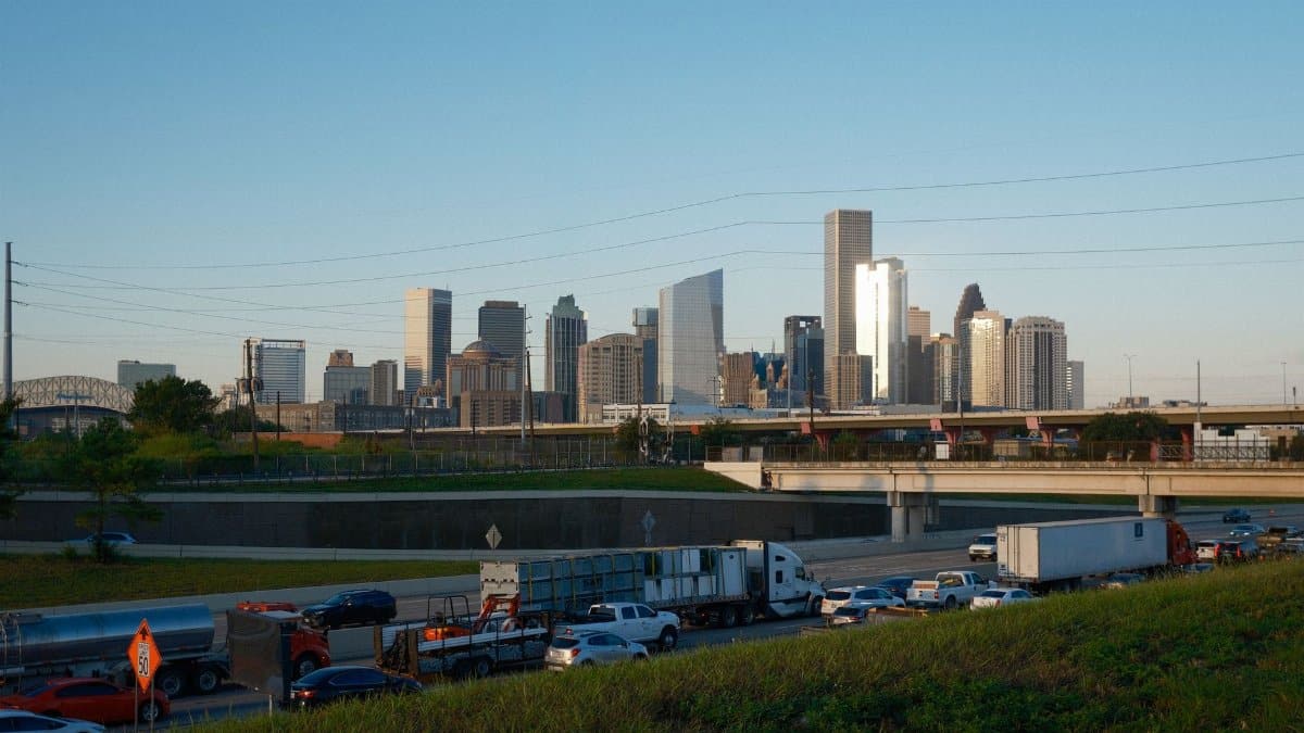 Captivating view of Houston skyline with bustling highway traffic at sunset.
