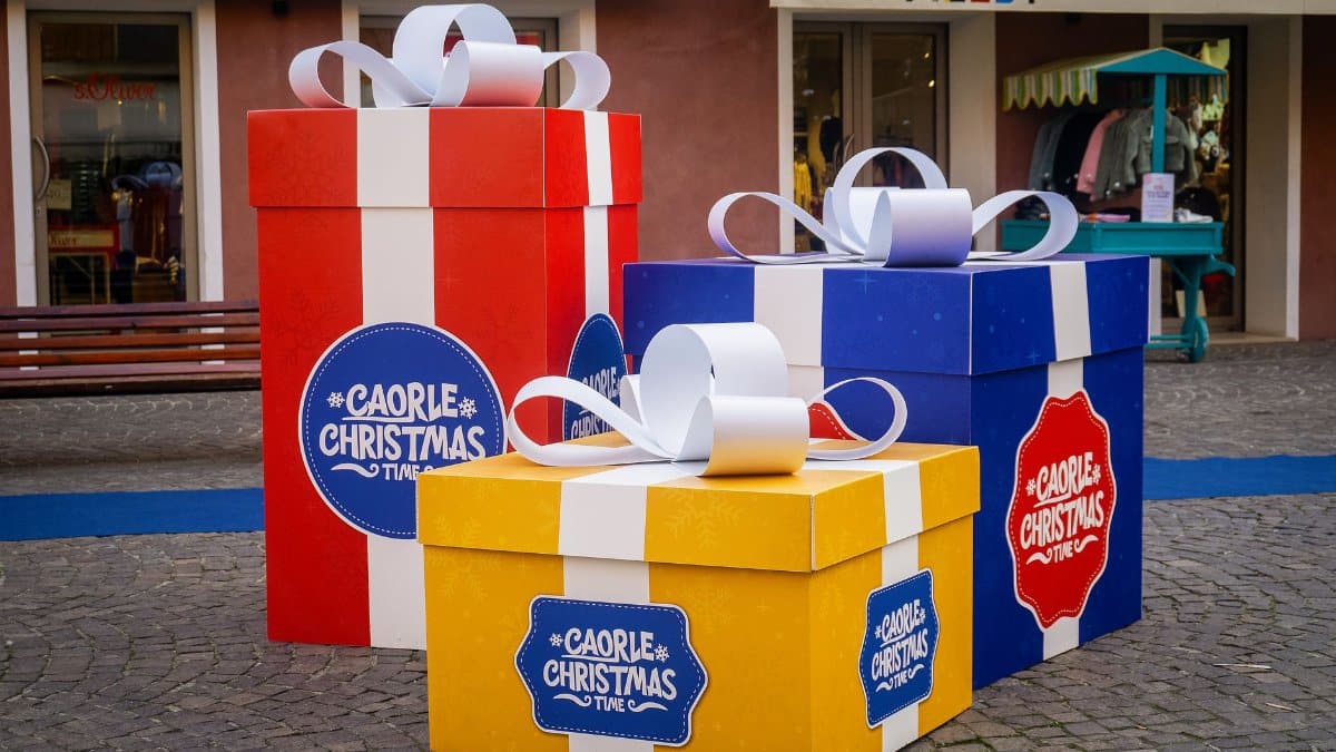 Vibrant oversized gift boxes in an outdoor shopping area, perfect for holiday themes.