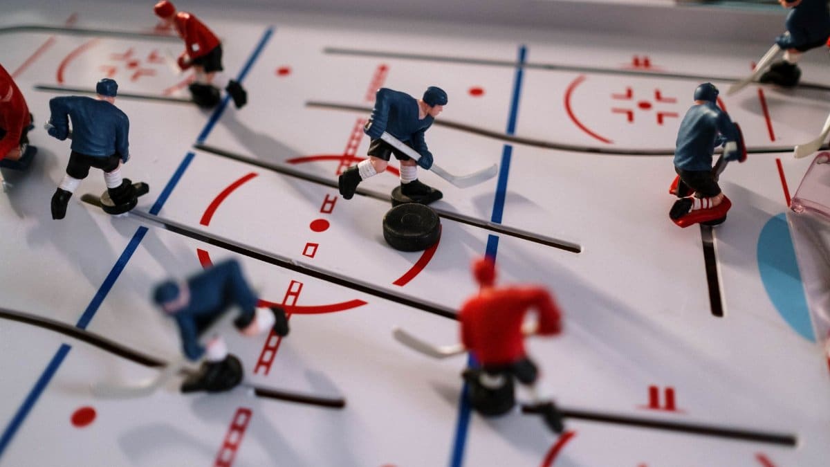 Closeup on a table hockey game showcasing figurines in motion on the playing field.