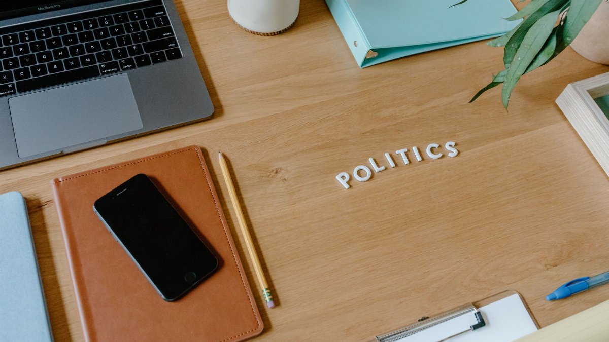 Neat office desk setup with laptop, smartphone, and political theme.