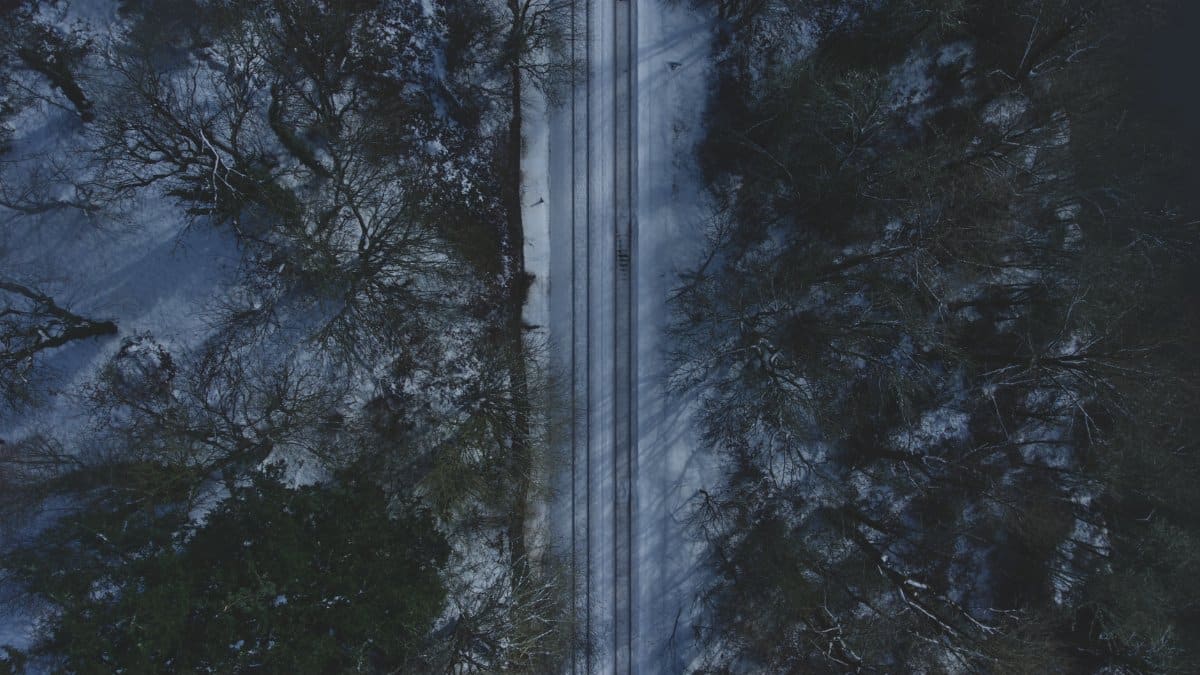 A stunning bird's-eye view of snow-covered train tracks amidst a winter forest in Washington State.