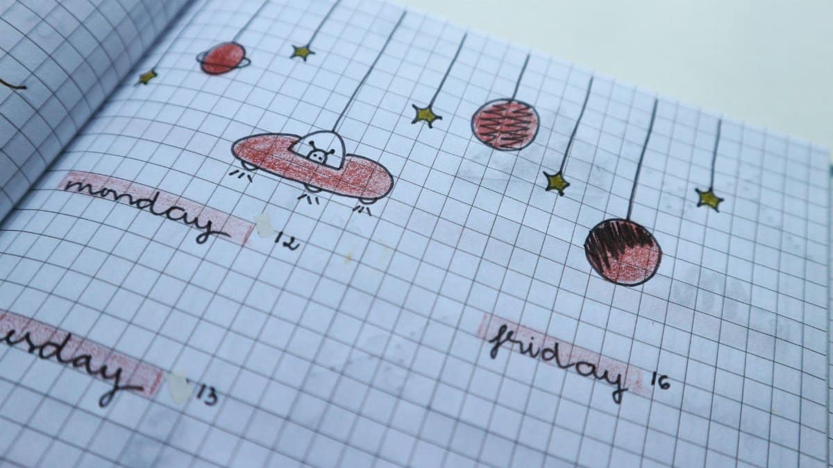 Close-up of a hand-drawn weekly planner page with cute, creative designs and grid layout.
