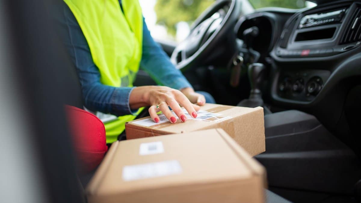 Courier organizing parcels inside a vehicle, highlighting the delivery process. Perfect for logistics themes.