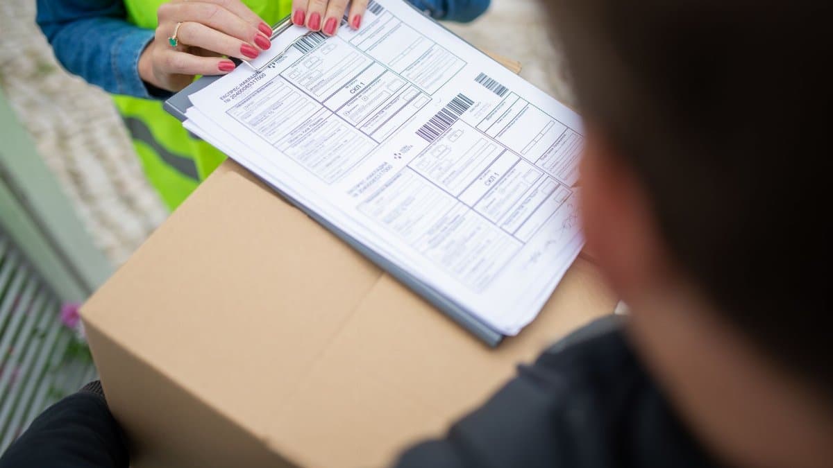 Courier hands over a package for delivery with signing of receipt documents.