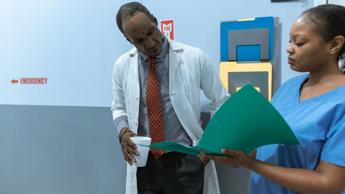 Doctors and nurse discussing medical charts in hospital setting.