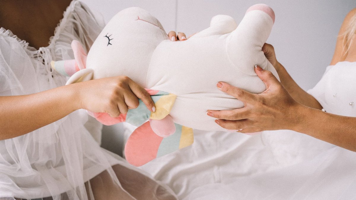 A playful tug-of-war with a colorful unicorn plush toy. Ideal for children's play concepts.