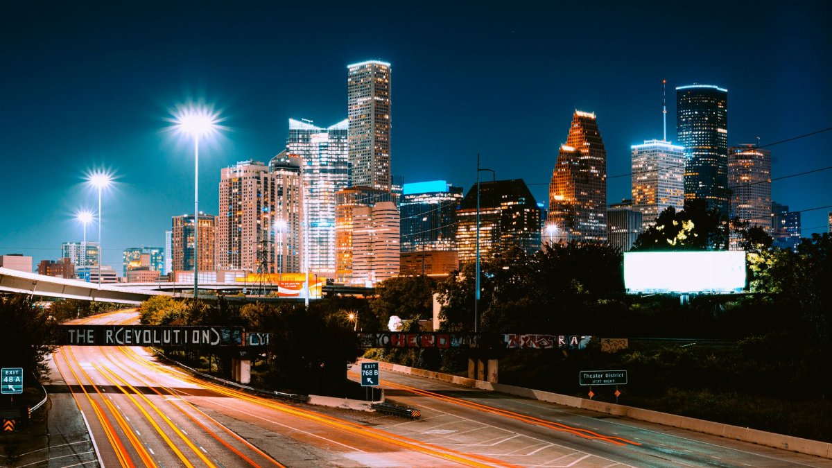 Captivating view of Houston's skyline at night with light trails and illuminated buildings.