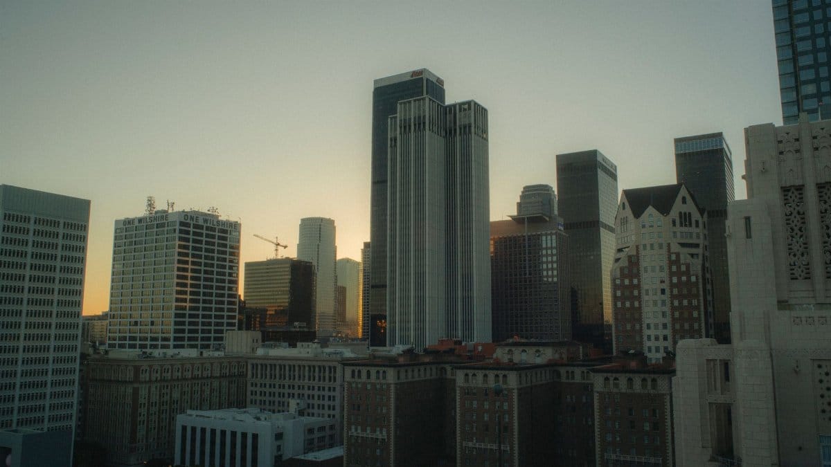 Dramatic view of Los Angeles skyscrapers at sunset, capturing urban architecture and vibrant city life.