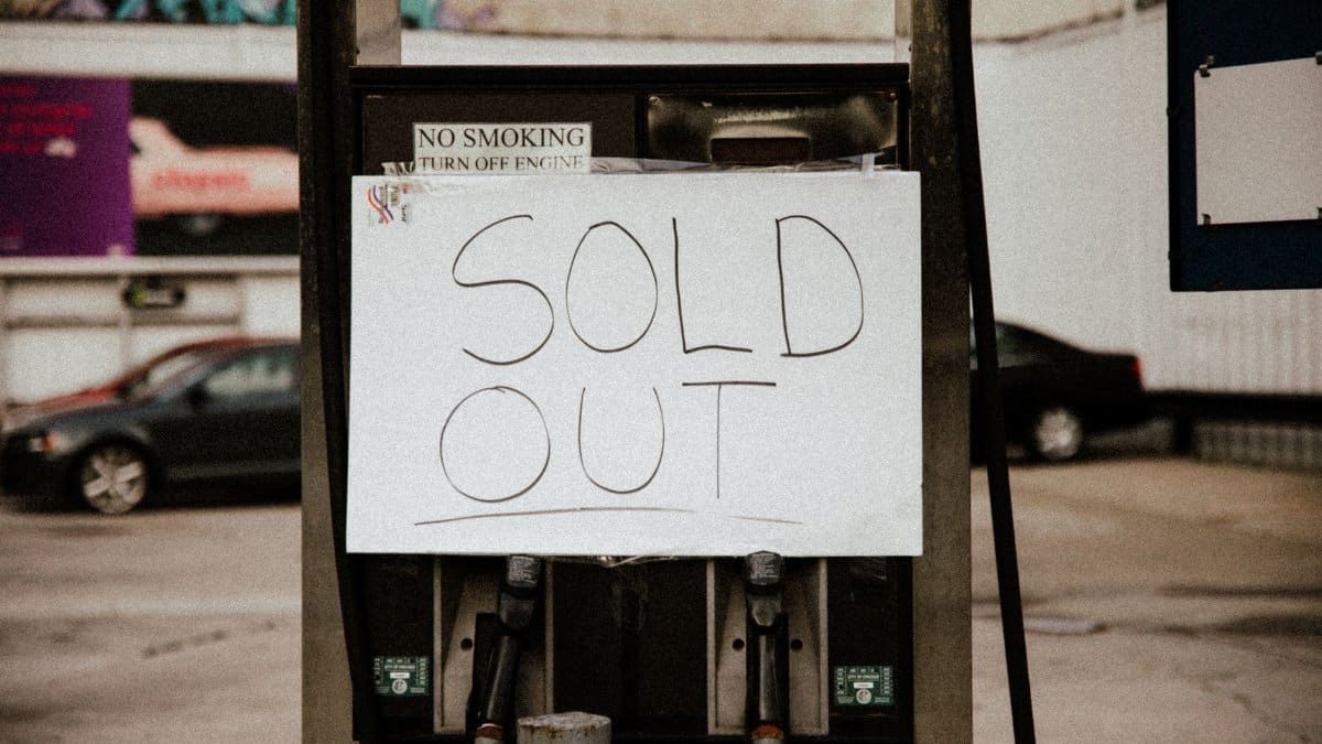 A gas pump at an urban station displaying a 'Sold Out' sign, illustrating fuel shortage.