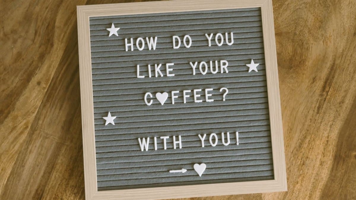 A cute, romantic coffee-themed message displayed on a felt letter board with decorative stars and hearts.