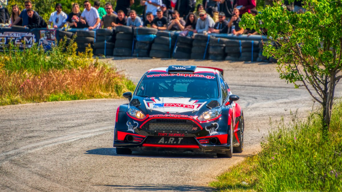 Rally car in action at a vibrant racing event in Ritsona, Greece. Spectators watching enthusiastically.
