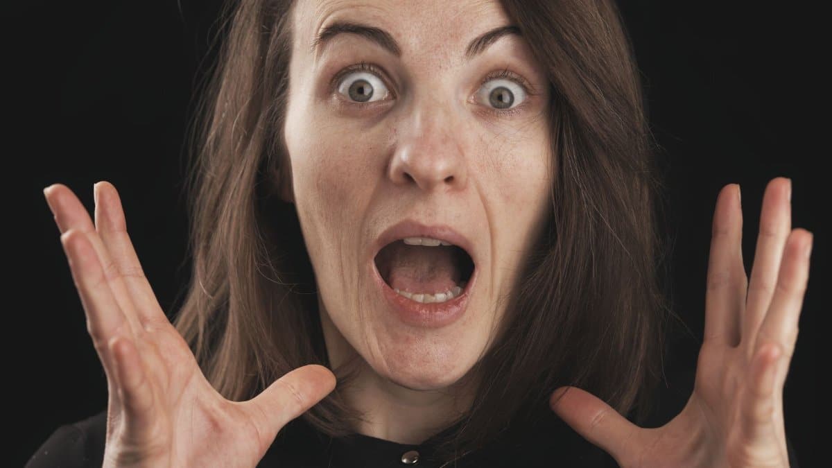 Close-up of a woman expressing shock and surprise with wide eyes and open mouth.