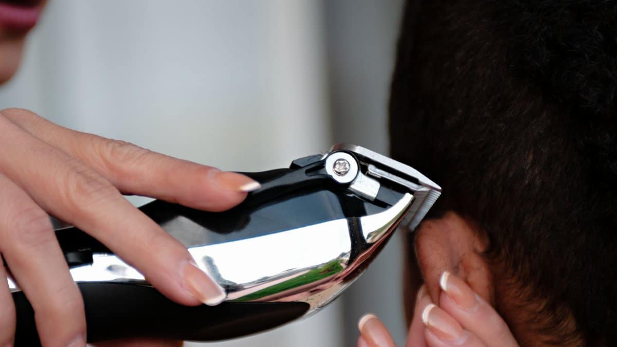 A detailed view of a hair clipper being used to cut hair. Ideal for grooming and barbering concepts.
