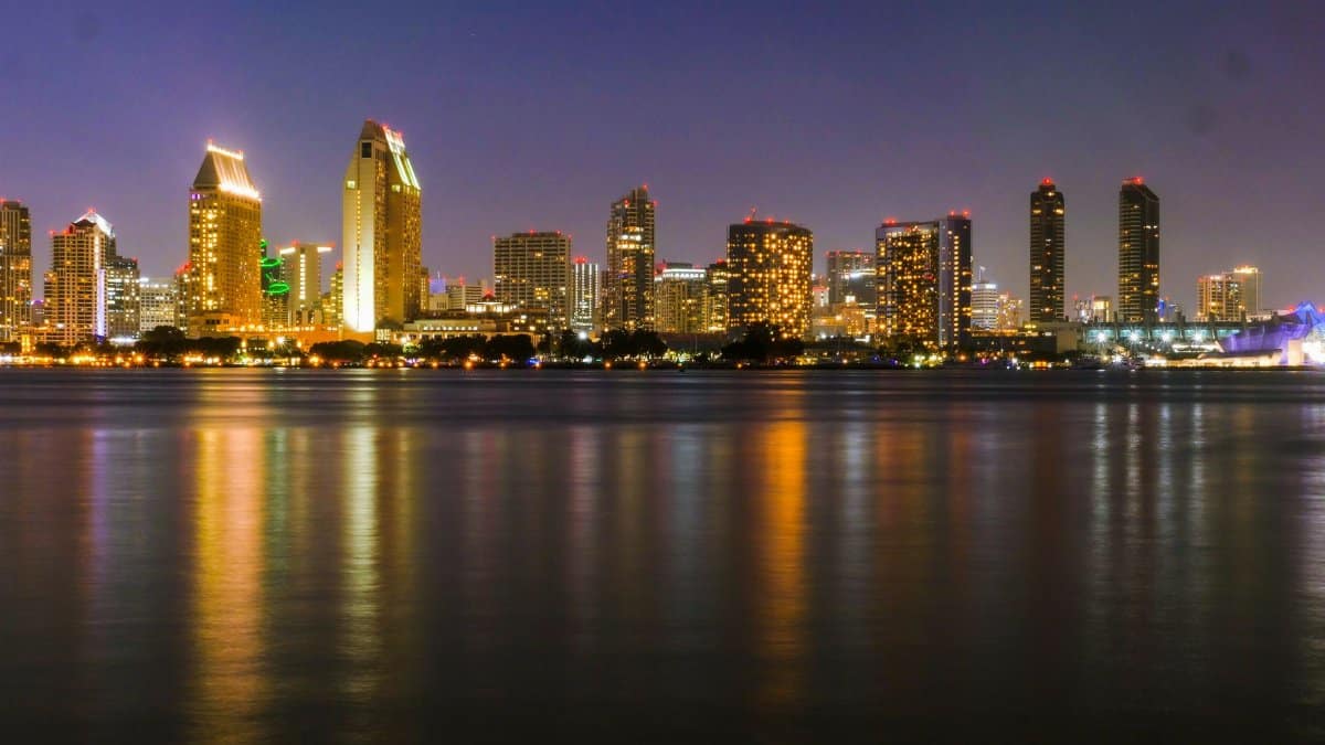 Stunning night view of San Diego's illuminated skyline with calm waterfront reflections.