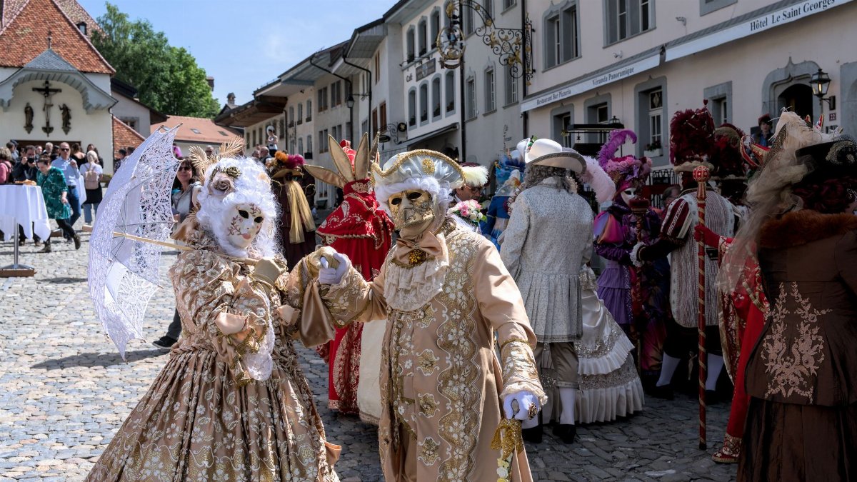 Vibrant costumes and masks at a Renaissance festival in Gruyères, Switzerland.