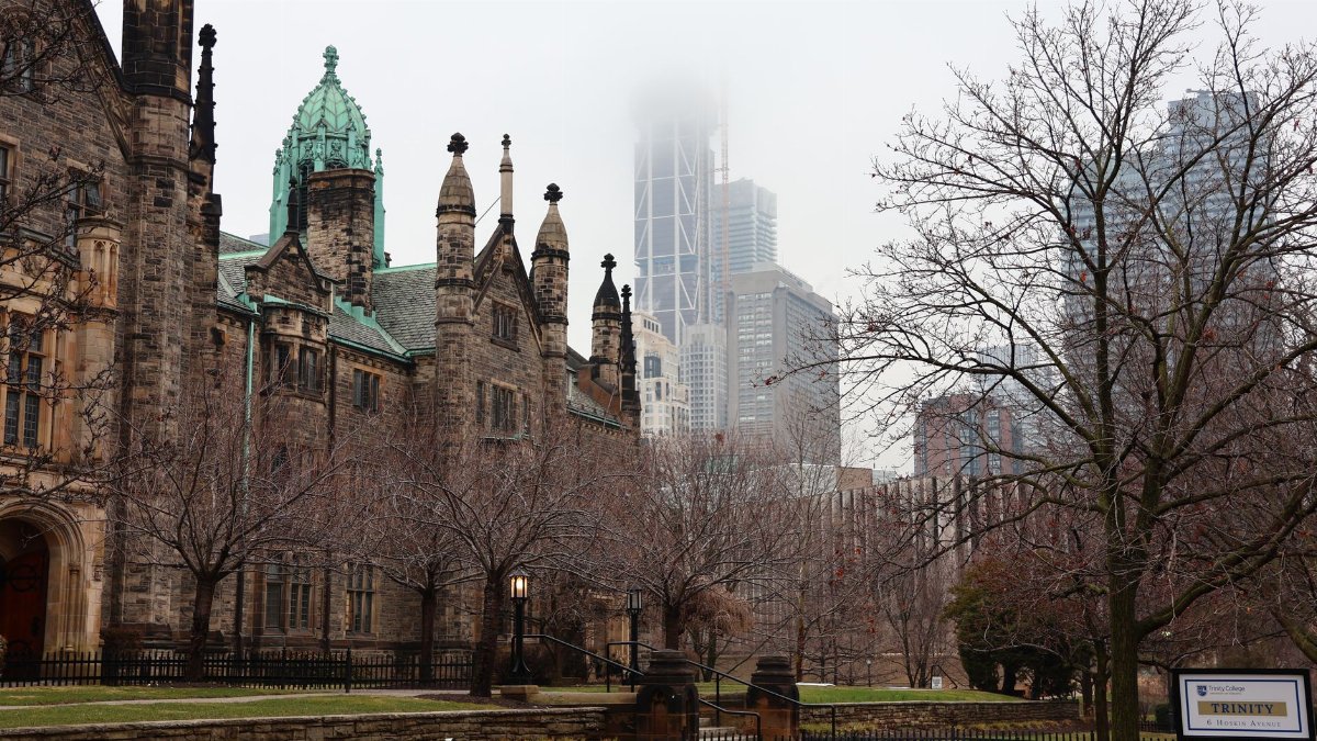 A blend of historic and modern architecture enveloped in fog in a city landscape.