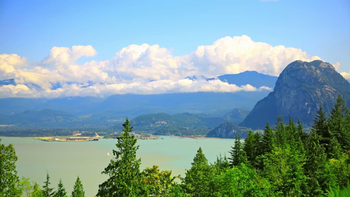 A breathtaking view of Howe Sound with coastal mountains under a bright summer sky.