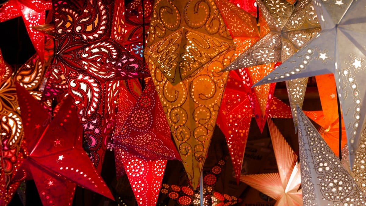 Colorful paper lanterns illuminate a festive night market atmosphere.